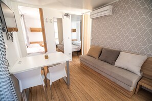 Relax in a stylish room with a desk, sofa, and mirror, set against a geometric-patterned wall.