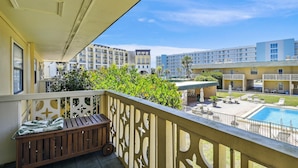Un balcon donnant sur une piscine et les bâtiments adjacents.