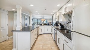 A modern kitchen with white cabinetry, a black countertop, and a central island. - IR 315 Beautiful 2 bedroom/2 bath (Destin)