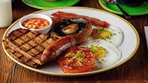 A breakfast plate with grilled toast, sausages, bacon, eggs, mushrooms, and beans. - The Boathouse (Bath)