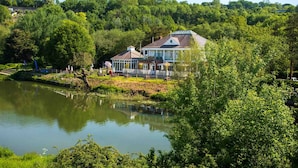 A lakeside hotel with a large building, a dock, and a bridge. - The Boathouse (Bath)