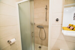 Chuveiro, secador de cabelo, toalhas de banho, papel higiênico