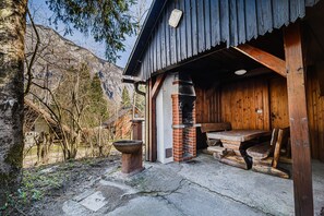 Un chalet rustique en bois, doté d’un banc en pierre et d’une cheminée.