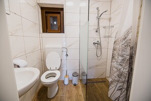 Een douche, handdoeken, shampoo, toiletpapier