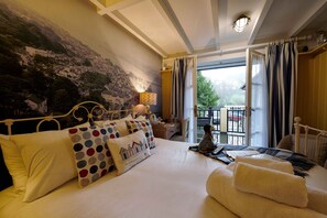 A hotel room with a large bed, a view of a balcony, and a mural on the wall. - The Ness House (Teignmouth)