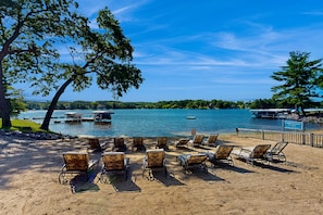 Relax on the sandy beach, surrounded by lush greenery and serene lake views.