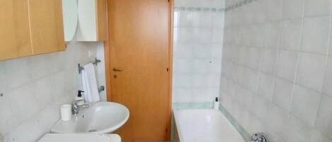 Ein Badezimmer mit Waschbecken, Spiegel und Badewanne.