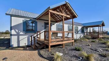 A two-story house with a wooden deck and a metal roof.