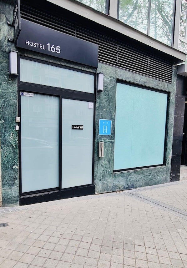 A building with a sign reading "Hostel 165" and a blue handicap accessibility sign. - Hostel 165 (Madrid)