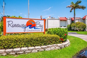 Une enseigne indiquant l’emplacement du complexe d’appartements Runaway Bay, avec une vue dégagée sur la façade de l’immeuble.