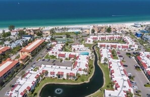 A resort with multiple buildings, a central water feature, and a beach in the background. - Island time at Runaway Bay by A Shore Thing Vacations (Bradenton Beach)