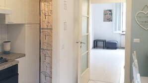 A kitchen with a countertop, a dishwasher, and a door leading to a living area with a view of the outside. - Cleo Tulipano (Falconara Marittima)