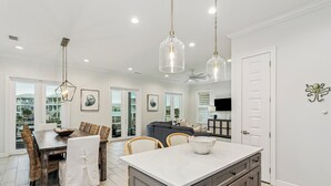 Una cucina moderna con zona pranzo, ampie finestre e vista esterna.
