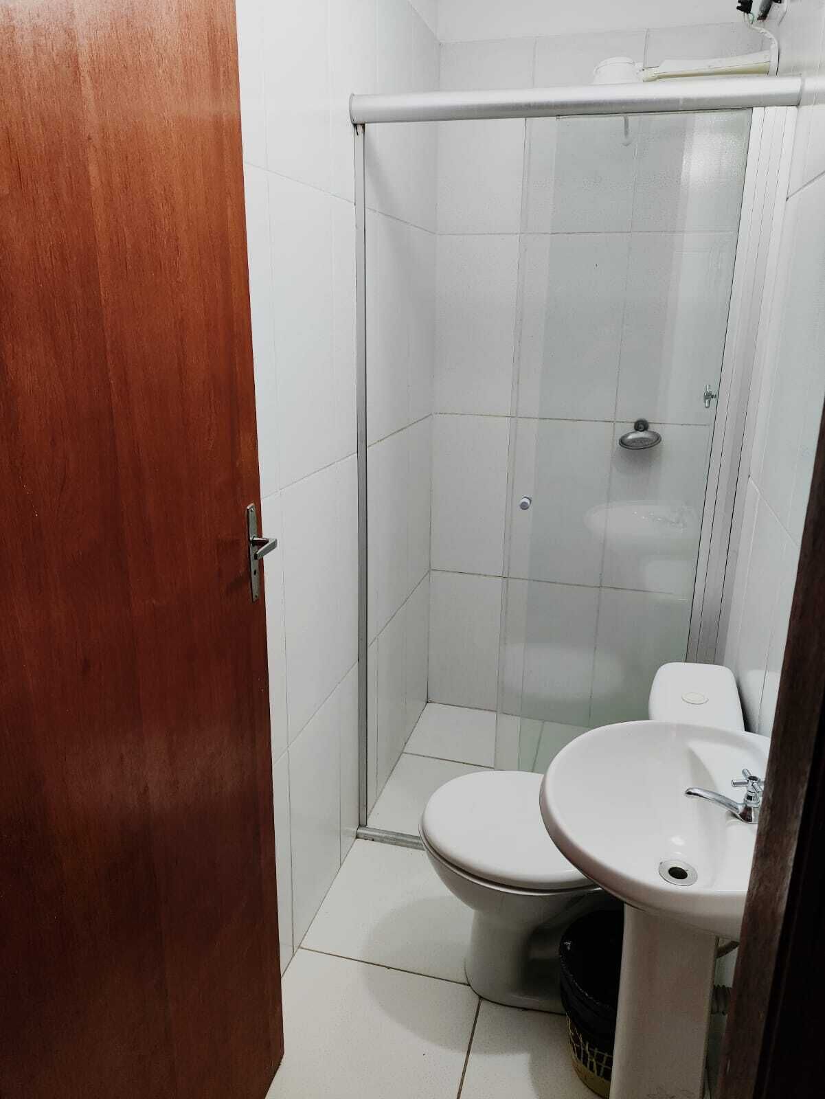 A small bathroom with a toilet, sink, and shower.