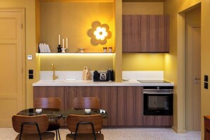Una cocina compacta con una isla central, horno integrado y una lámpara fijada a la pared.