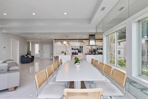 Un área de comedor moderna con una mesa larga, sillas y una planta en maceta.