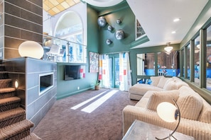 A spacious lobby with a staircase, seating area, and a large window offering a view of the outdoors. - Skyline Villa Indoor Pool (Elkhorn)