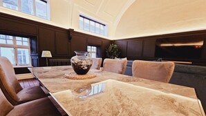 A spacious room with a large marble table, comfortable seating, and a television. - Unique town centre apartment with vaulted ceiling - Pass the Keys (Shrewsbury)