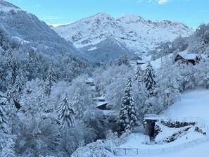 A snow-covered mountain landscape with a small cabin and a stone structure. - Mountain River Resort (Val d'Illiez)