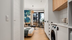 Un apartamento moderno con un dormitorio, comedor y cocina.