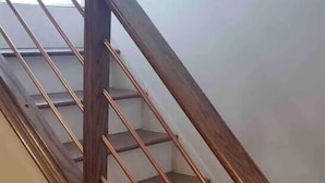 Een houten trap met een leuning en een plateau.