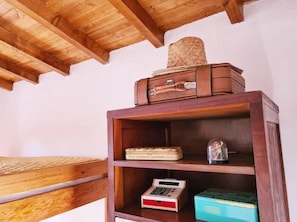 A wooden shelf with a suitcase, a box labeled 'MILE CHOCOLATE ASSORTED NUTS,' a small electronic device, and a blue box.