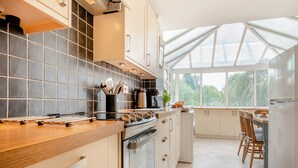 A modern kitchen with a large window, a stove, and a sink.