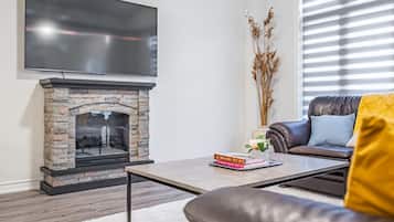 Villa Deluxe | Área de sala de estar | Smart TV de 65 pulgadas con canales digitales, chimenea y Netflix