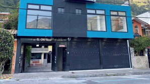 Um edifício de dois andares com uma placa que diz 'HOTEL EL CASTILLO'.