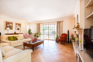 Un salon avec un canapé, une table basse, une cheminée et un téléviseur.