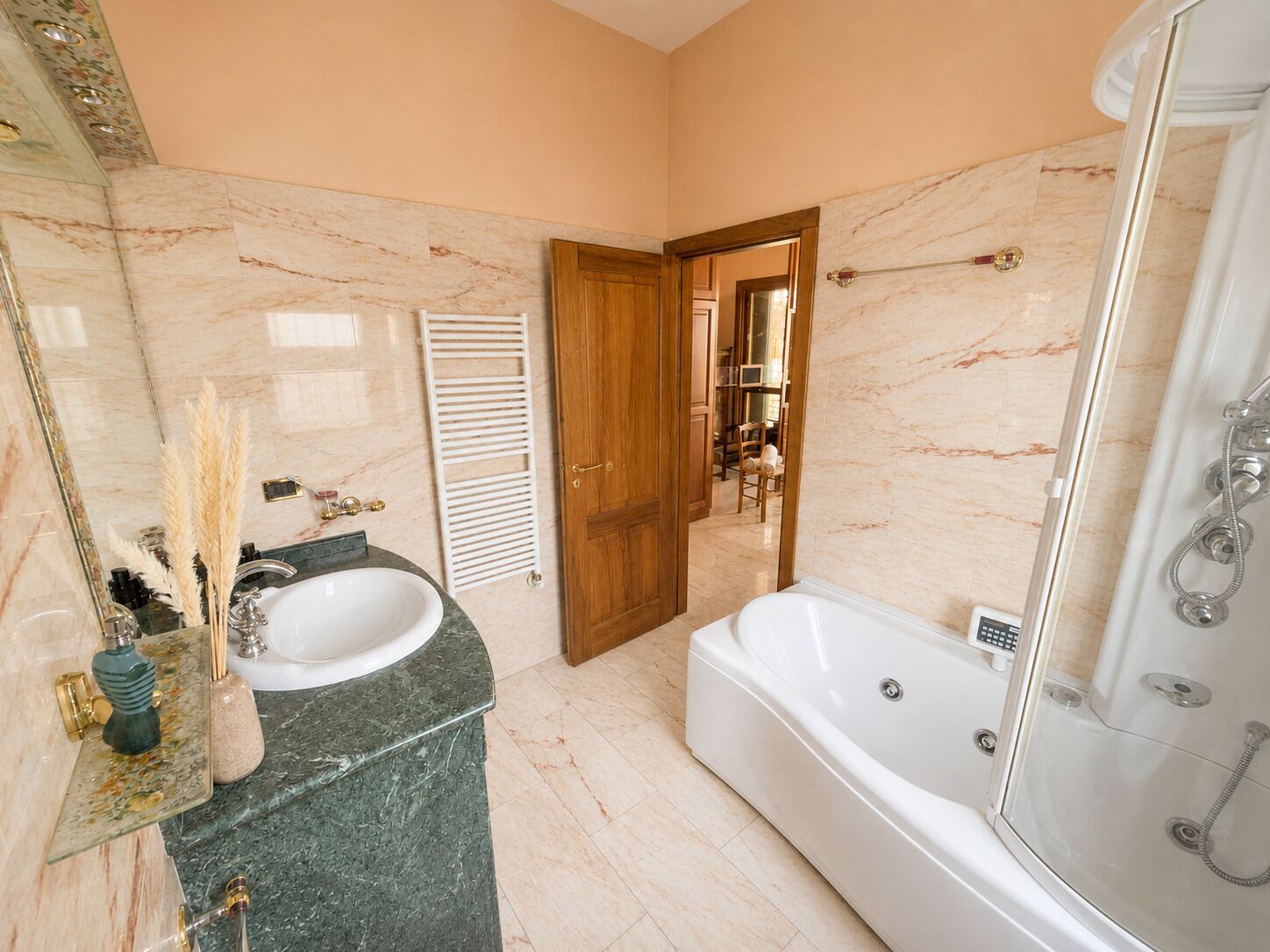 Un baño con lavamanos de mármol, bañera y ducha.