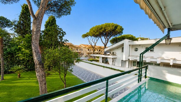 A residential area with a swimming pool, a staircase, and a view of neighboring houses.