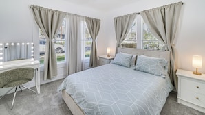 A bedroom with a bed, bedside tables, a vanity with lights, and a ceiling fan. - Charming San Antonio Home ~ 2 Mi to The Alamo! (San Antonio)