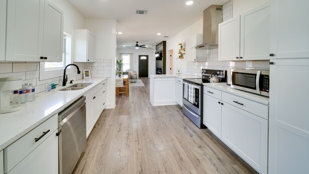 A modern kitchen with white cabinetry, a dishwasher, a microwave, and a stove. - Charming San Antonio Home ~ 2 Mi to The Alamo! (San Antonio)