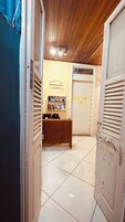 Um corredor com teto de madeira, uma receção e uma parede com o letreiro 'Panorama Inn'.