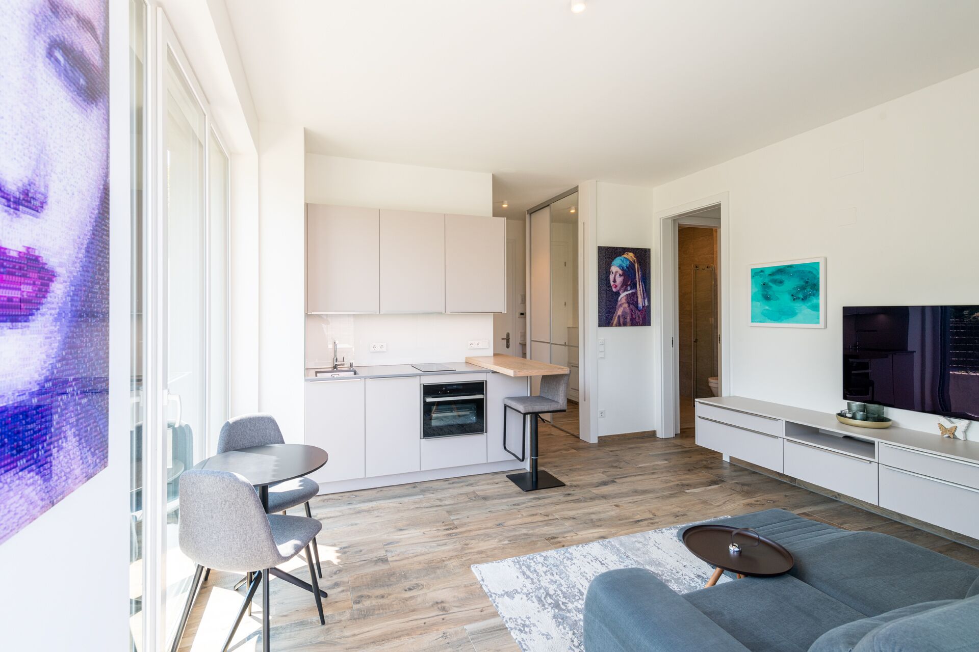 A modern apartment with a kitchen, dining area, and living room.