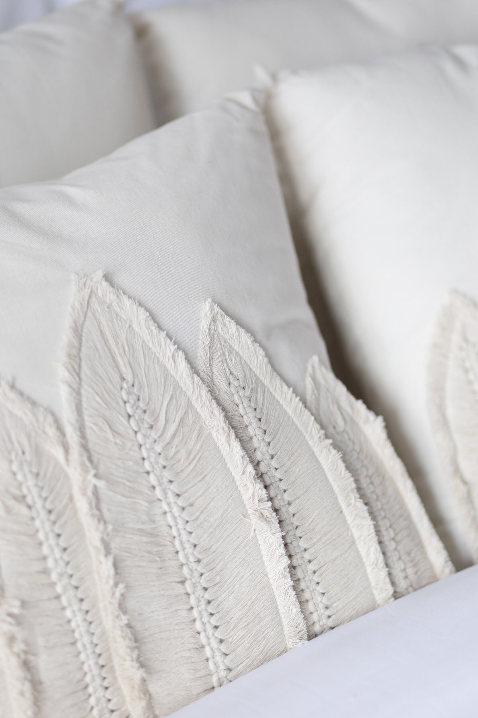 A close-up of a bed with neatly arranged pillows.