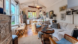 A cozy, well-lit room with a dining area, a sofa, and a kitchen in the background. - Holiday Home 'Villa Cap Ferret Centre Ref 222' with Private Terrace (CAP-FERRET)
