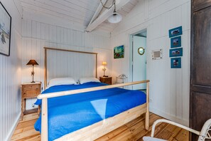 A bedroom with a wooden bed, two bedside tables with lamps, a wooden chair, and a wardrobe.