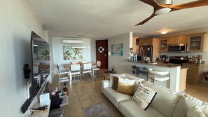 A spacious living area with a sofa, a dining table, and a kitchen with modern appliances.