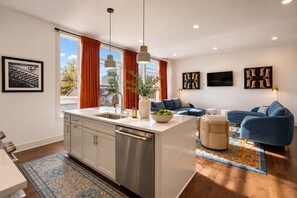 A modern apartment with a kitchen, dining area, and living room.