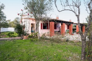 Ein Haus mit Garten, einer Ziegelaußenwand und einer roter Tür.