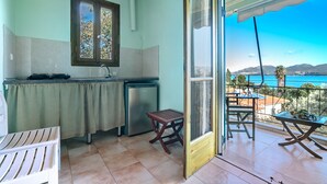 A kitchen with a window, a small table, and a view of the sea. - Studio Apartment 'Old Boat Double  10' with Sea View, Wi-Fi and Air Conditioning (Lefkada)