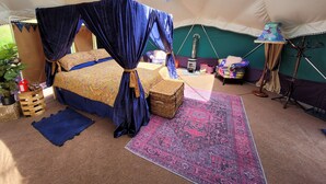 A cozy bedroom with a canopy bed, a small heater, a lamp, and a view of the outdoors. - Hideaway Escapes (Narberth)