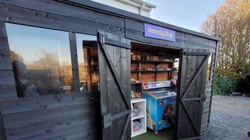 A wooden shop with a sign reading "Honesty Shop" and a display of ice cream.