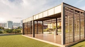 Un edificio moderno con tetto piatto, ampie finestre e un'area esterna coperta.