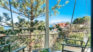 Ein Balkon mit Tisch, Stühlen und Blick auf Berge und ein Gewässer.