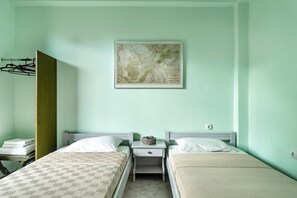 A room with two beds, a nightstand, a wall-mounted map, and a coat rack.