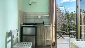 Une cuisine de taille réduite, équipée d’un réfrigérateur, d’une petite table et d’une chaise.