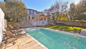A pool area with lounge chairs and a stone wall. - House 2303/98197 (Istria - Rakovci), 10000m from the beach (Rakovci)